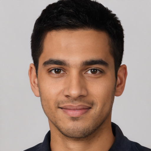 Joyful latino young-adult male with short  black hair and brown eyes