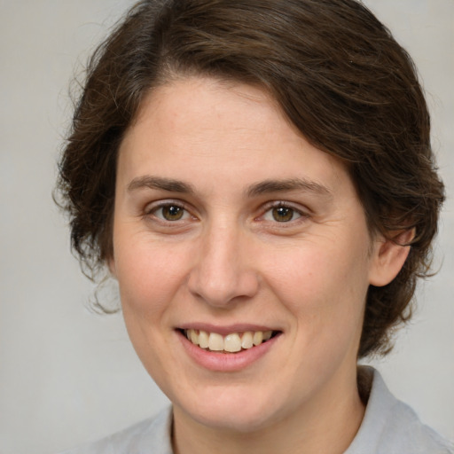 Joyful white young-adult female with medium  brown hair and green eyes