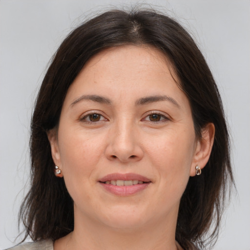 Joyful white adult female with medium  brown hair and brown eyes