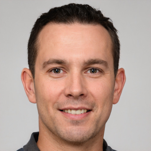 Joyful white young-adult male with short  brown hair and brown eyes