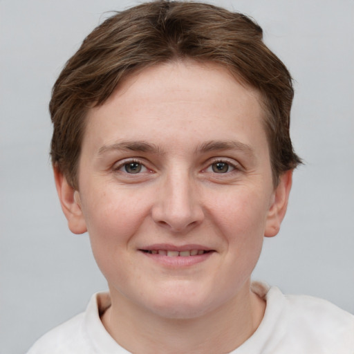 Joyful white young-adult female with short  brown hair and grey eyes