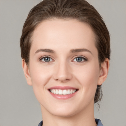 Joyful white young-adult female with short  brown hair and grey eyes