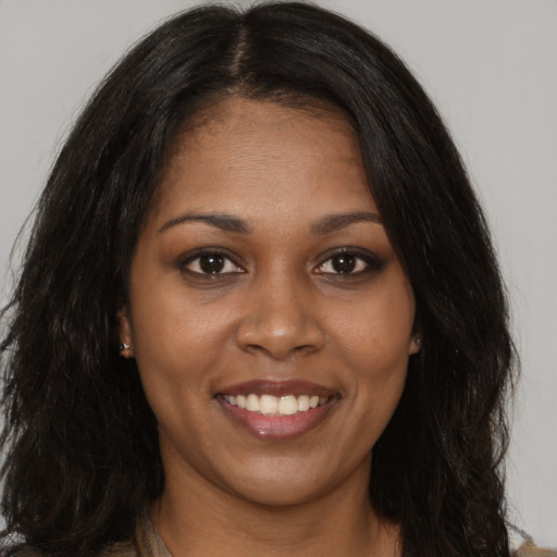 Joyful black young-adult female with long  brown hair and brown eyes