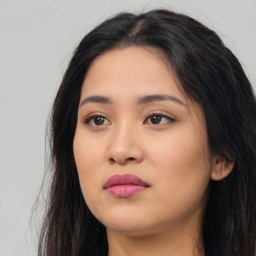 Joyful latino young-adult female with long  black hair and brown eyes