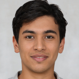 Joyful latino young-adult male with short  brown hair and brown eyes