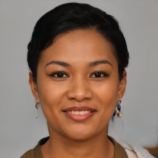 Joyful latino young-adult female with short  black hair and brown eyes