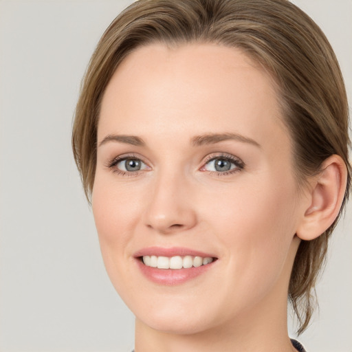 Joyful white young-adult female with medium  brown hair and blue eyes