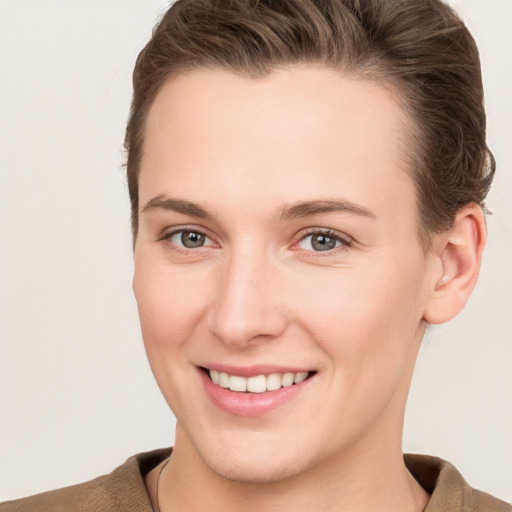 Joyful white young-adult female with short  brown hair and grey eyes