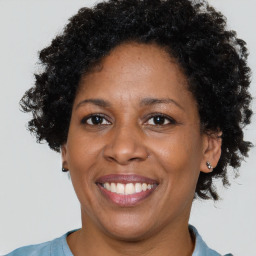 Joyful black adult female with short  brown hair and brown eyes