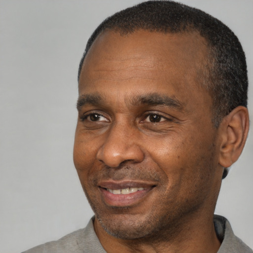 Joyful black adult male with short  brown hair and brown eyes