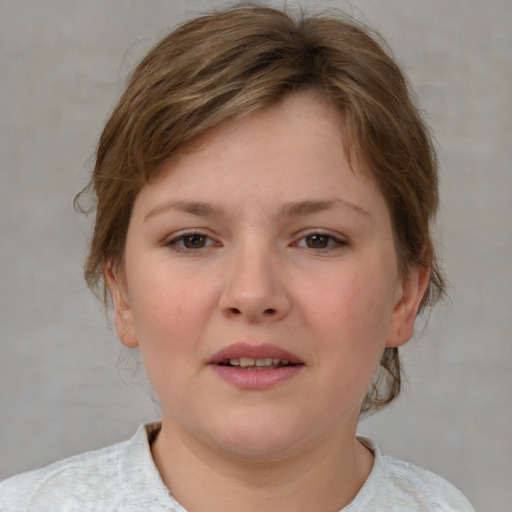 Joyful white child female with medium  brown hair and grey eyes