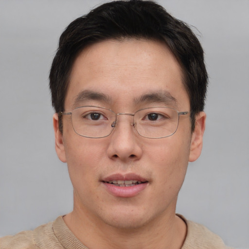 Joyful asian adult male with short  brown hair and brown eyes