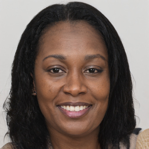 Joyful black adult female with long  brown hair and brown eyes