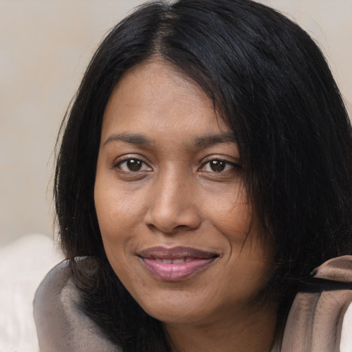Joyful black young-adult female with long  black hair and brown eyes