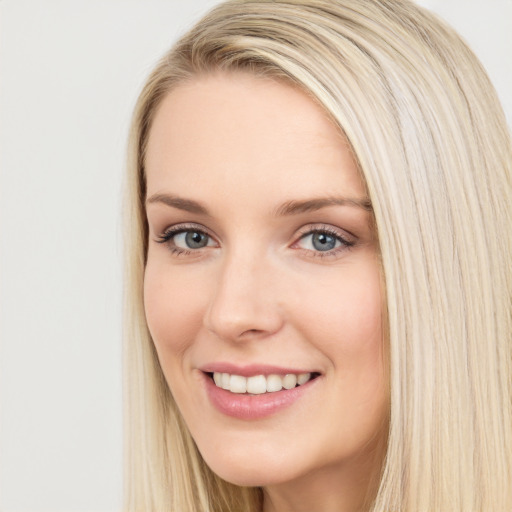 Joyful white young-adult female with long  brown hair and blue eyes