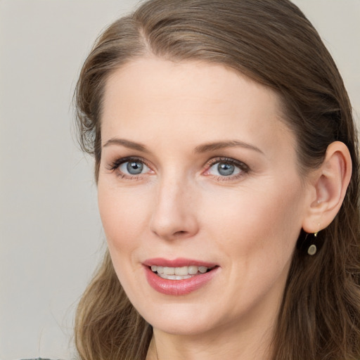 Joyful white young-adult female with long  brown hair and blue eyes