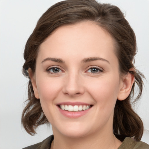 Joyful white young-adult female with medium  brown hair and green eyes