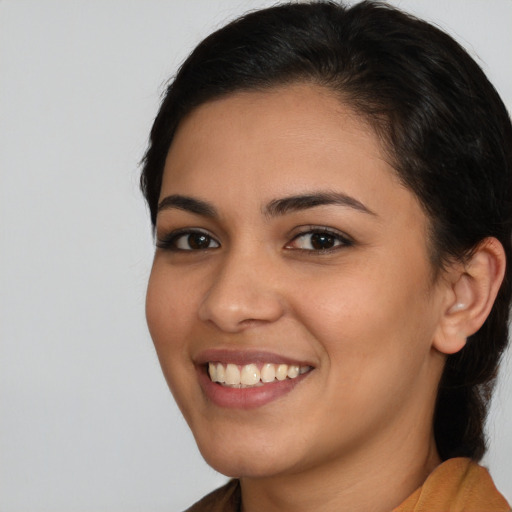 Joyful latino young-adult female with long  brown hair and brown eyes