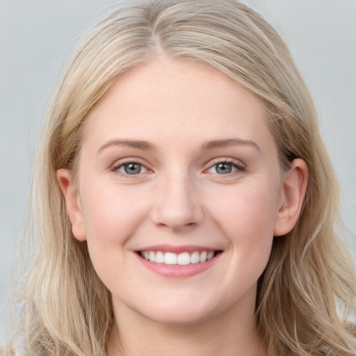 Joyful white young-adult female with long  brown hair and blue eyes