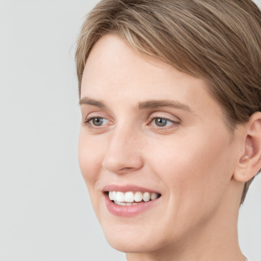 Joyful white young-adult female with medium  brown hair and blue eyes