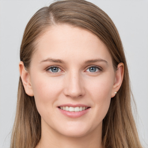 Joyful white young-adult female with long  brown hair and blue eyes