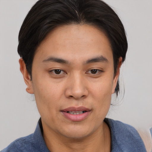 Joyful asian young-adult male with medium  brown hair and brown eyes