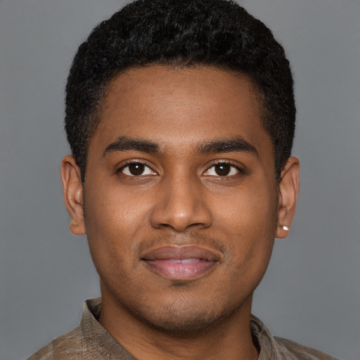 Joyful black young-adult male with short  brown hair and brown eyes