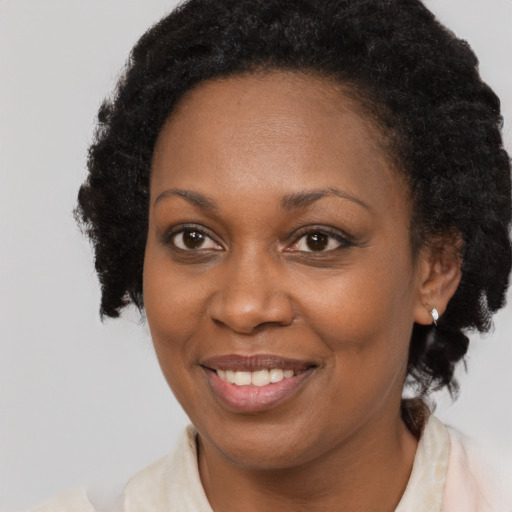 Joyful black young-adult female with medium  brown hair and brown eyes