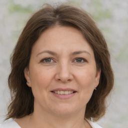 Joyful white adult female with medium  brown hair and grey eyes