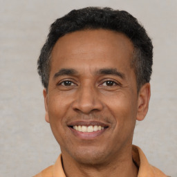 Joyful latino adult male with short  black hair and brown eyes