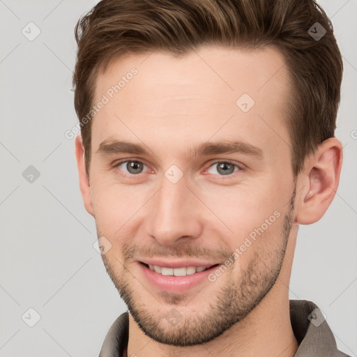 Joyful white young-adult male with short  brown hair and grey eyes