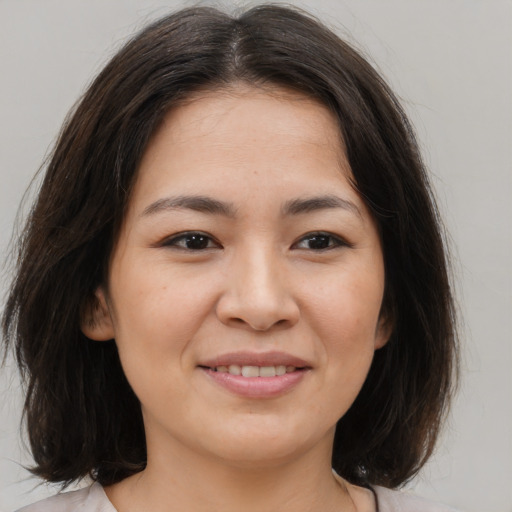 Joyful asian young-adult female with medium  brown hair and brown eyes