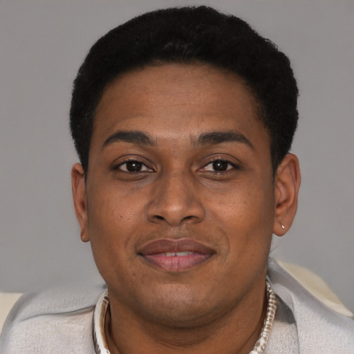 Joyful black young-adult male with short  brown hair and brown eyes