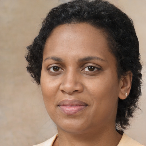 Joyful black adult female with medium  brown hair and brown eyes