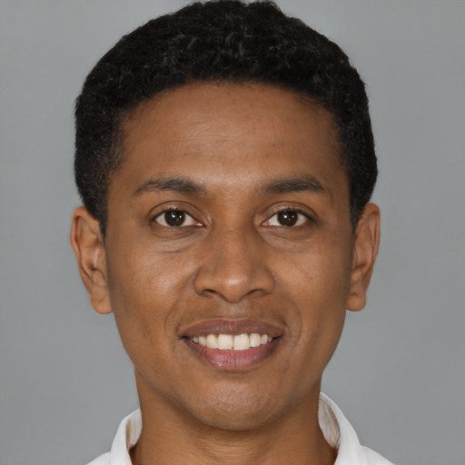 Joyful black young-adult male with short  brown hair and brown eyes