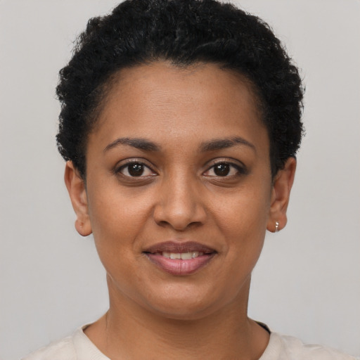 Joyful black young-adult female with short  black hair and brown eyes