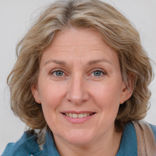 Joyful white adult female with medium  brown hair and blue eyes