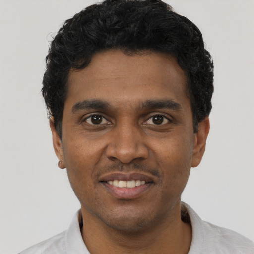 Joyful black young-adult male with short  black hair and brown eyes