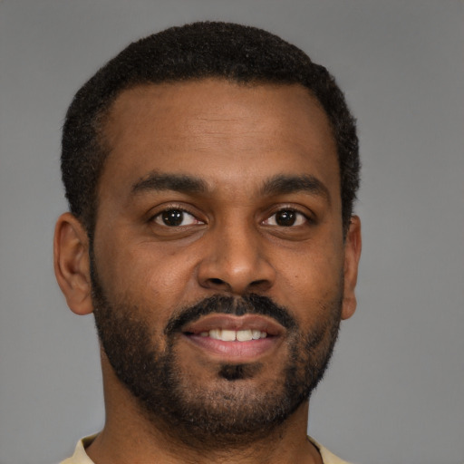 Joyful black young-adult male with short  brown hair and brown eyes