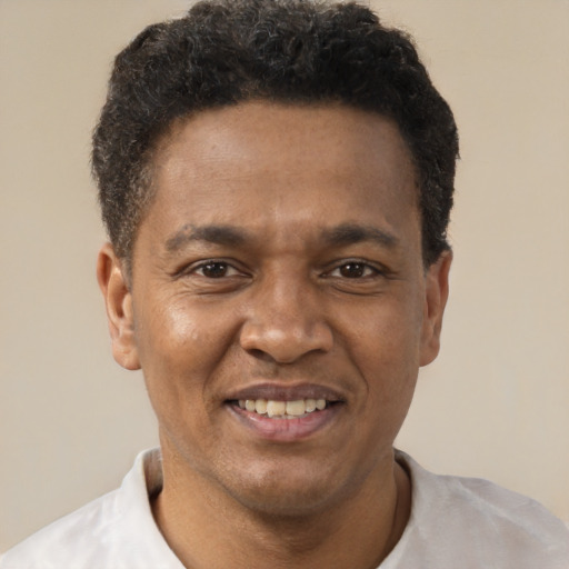 Joyful black adult male with short  brown hair and brown eyes