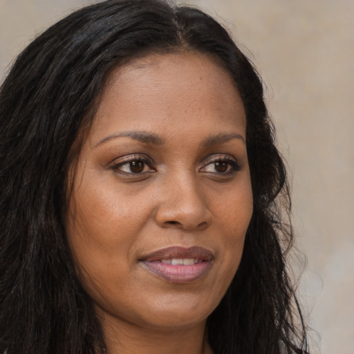 Joyful black young-adult female with long  brown hair and brown eyes