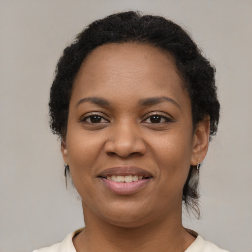 Joyful black young-adult female with short  brown hair and brown eyes