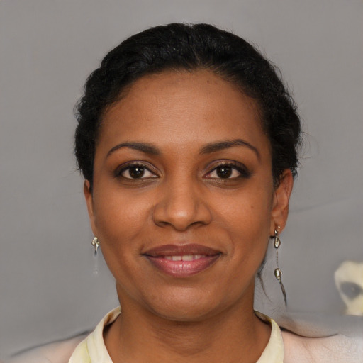 Joyful black young-adult female with short  black hair and brown eyes