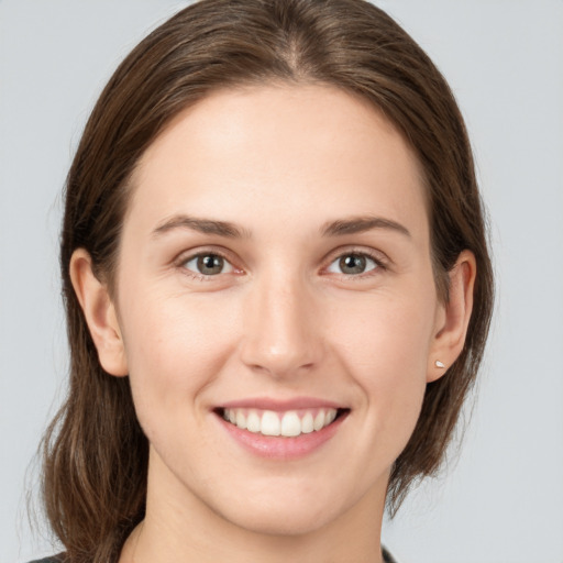 Joyful white young-adult female with medium  brown hair and grey eyes