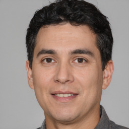 Joyful white adult male with short  black hair and brown eyes