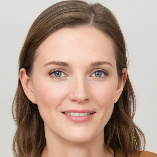 Joyful white young-adult female with long  brown hair and grey eyes