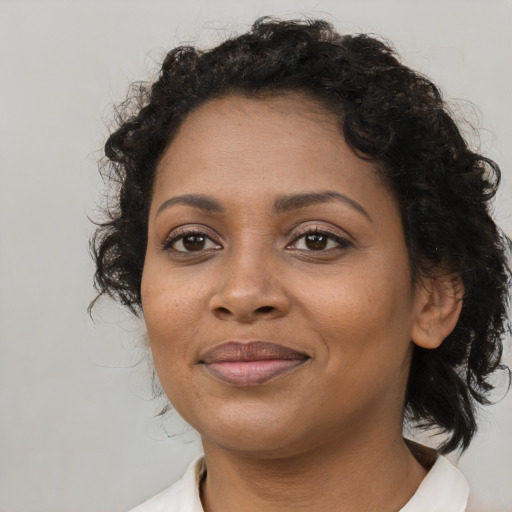 Joyful black adult female with medium  brown hair and brown eyes