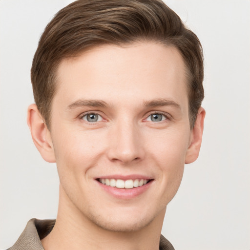 Joyful white young-adult male with short  brown hair and grey eyes