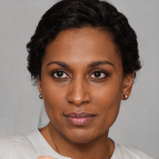 Joyful black young-adult female with short  black hair and brown eyes