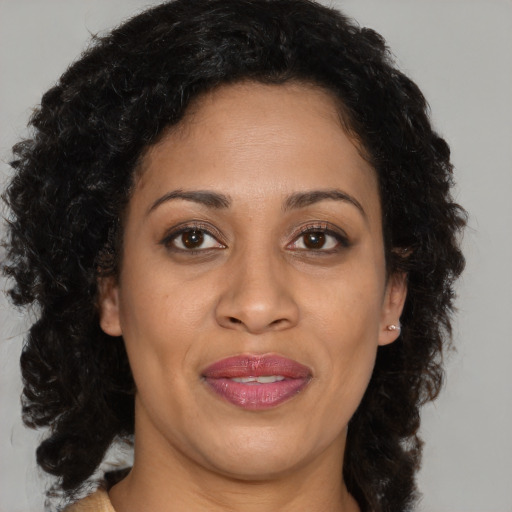 Joyful black adult female with long  brown hair and brown eyes